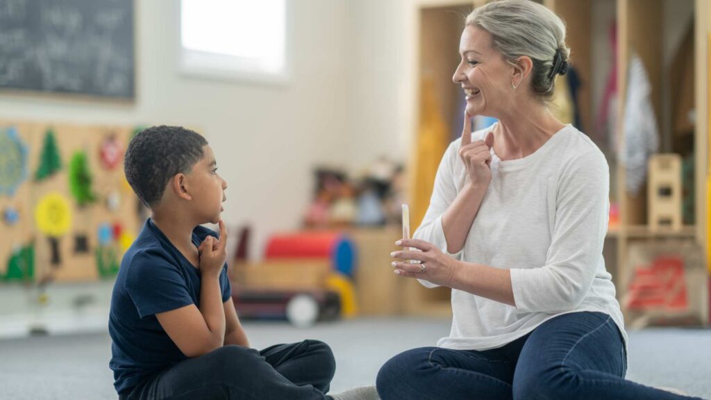 A therapist and child practicing ABA therapy in a playroom, supporting the child with autism level 1.