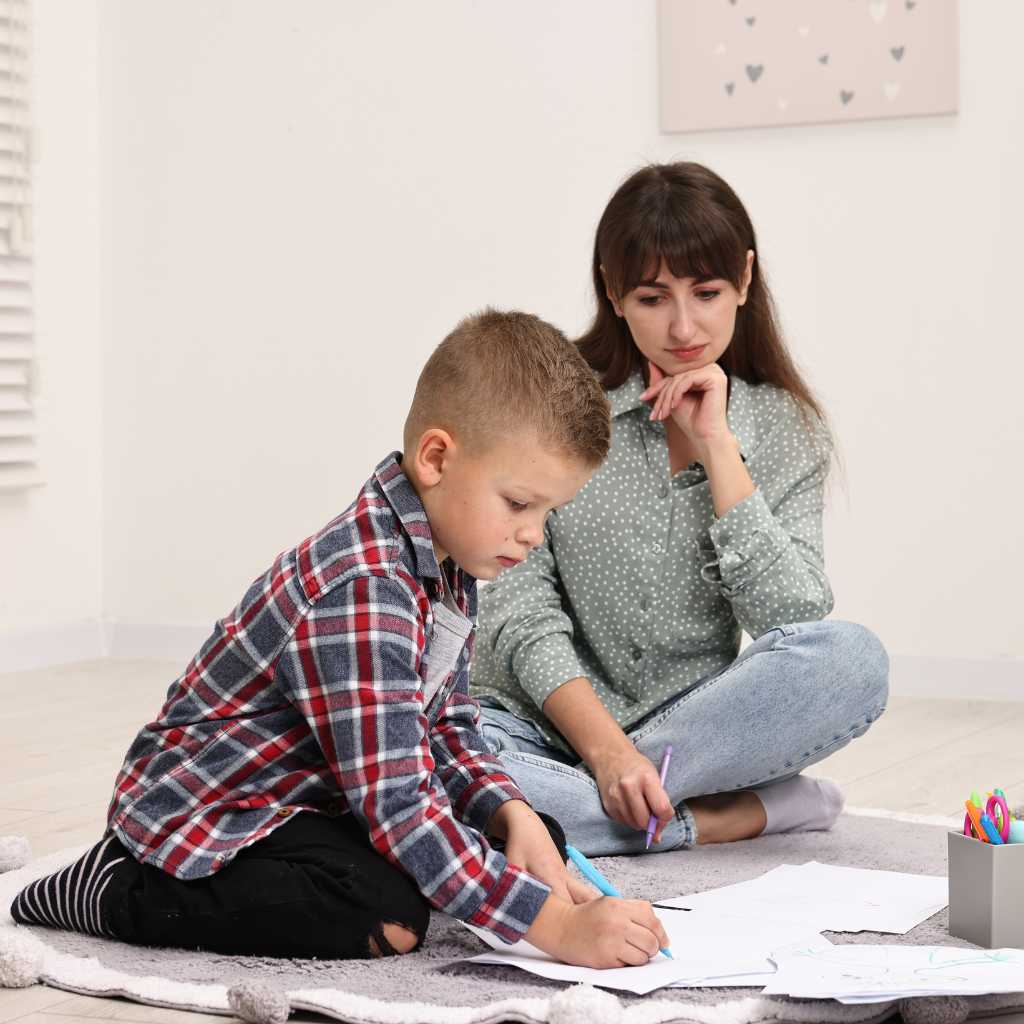 Child receiving early intervention support while working with an ABA therapist during a learning activity.