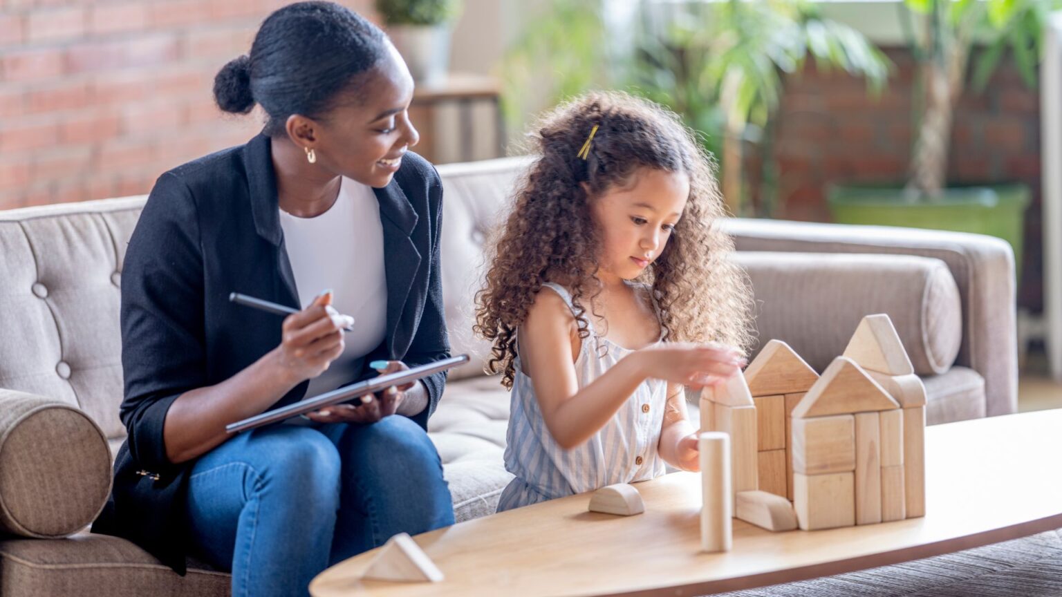 Therapist and child engaged in play therapy, highlighting the collaborative and joyful nature of the approach