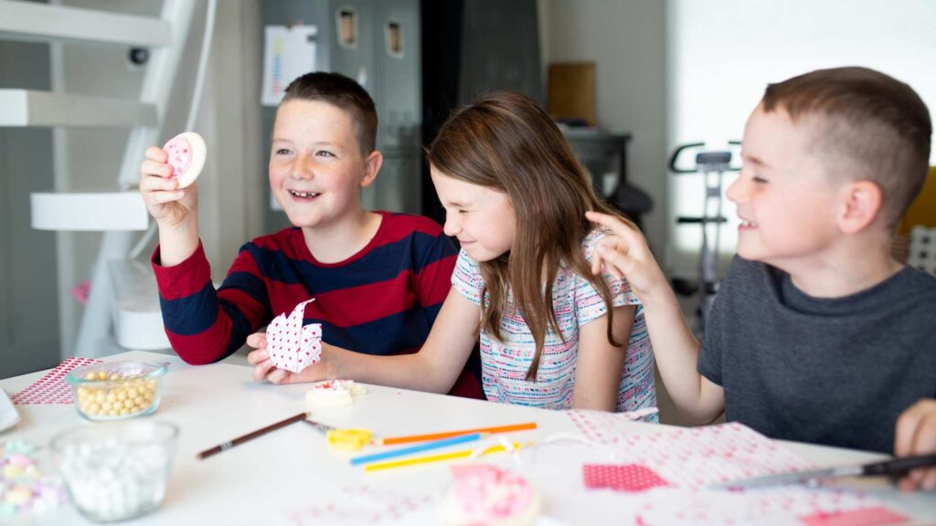Children sitting at a table making simple Valentine’s Day crafts