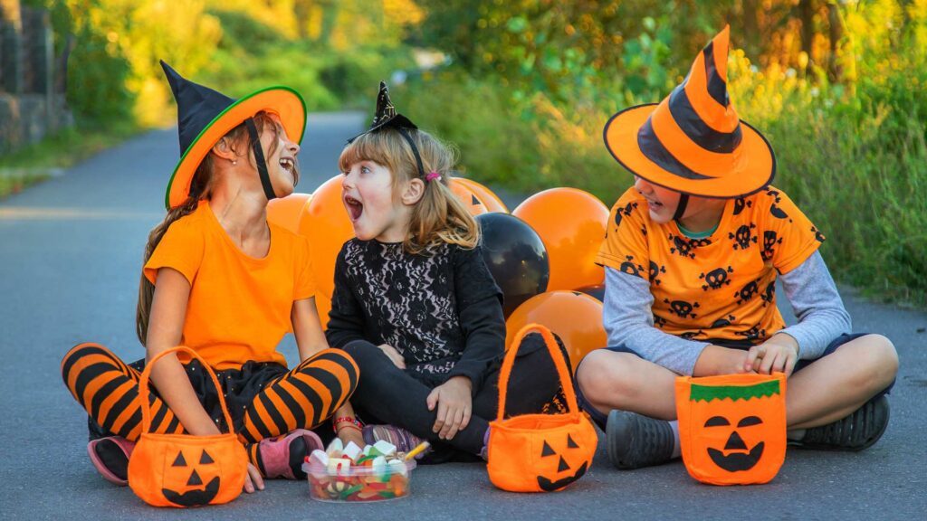 Kids in Halloween Costumes with Treats Outdoors