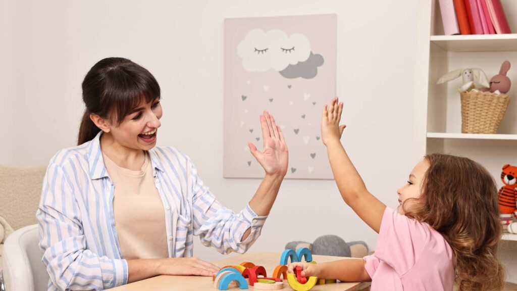 Smiling Psychologist Giving High Five to Little
