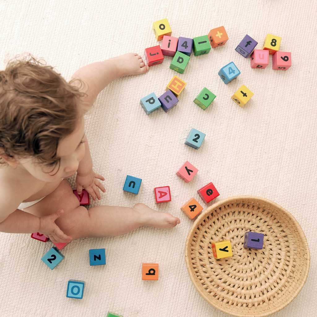 Toddler playing with letter and number blocks during ABA therapy for toddlers