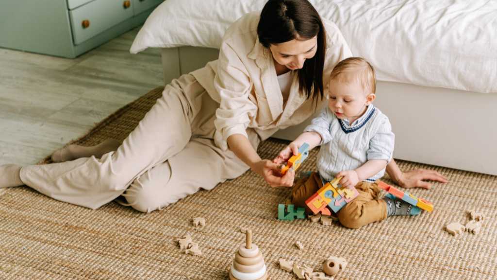 Caregiver supporting toddler during at-home ABA therapy activity